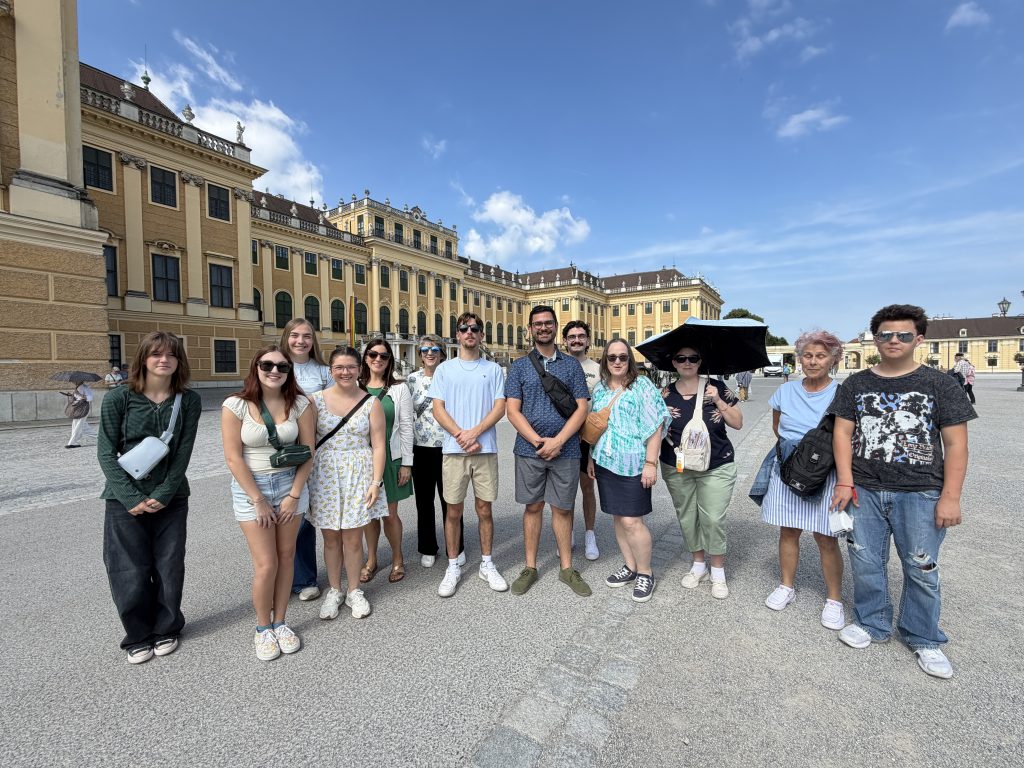 students posing in front of a large building