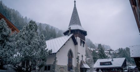A quaint church in a snowy mountain village.
